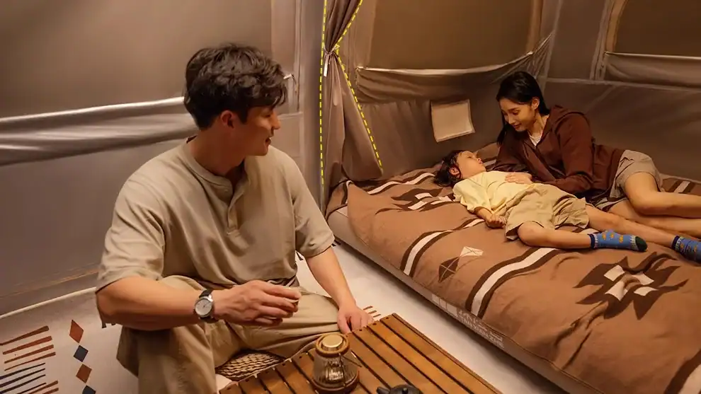 توفير الخيام الهوائية الكبيرة: دليل سعة 8-12 شخصاً 3 عائلة شابة تسترخي في خيمة تخييم مريحة.