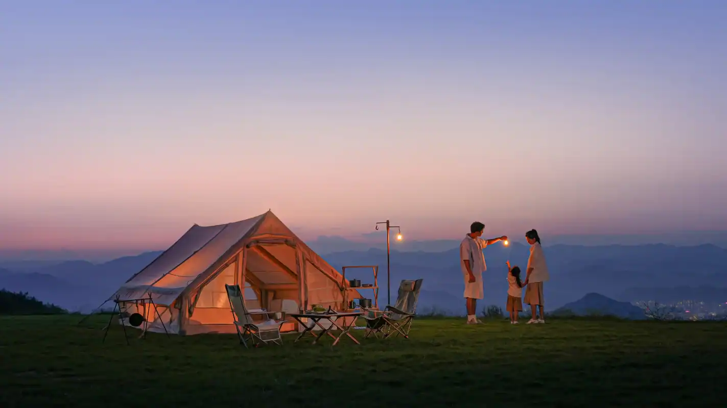 Camping scene with a tent and family enjoying the outdoors at sunset.
