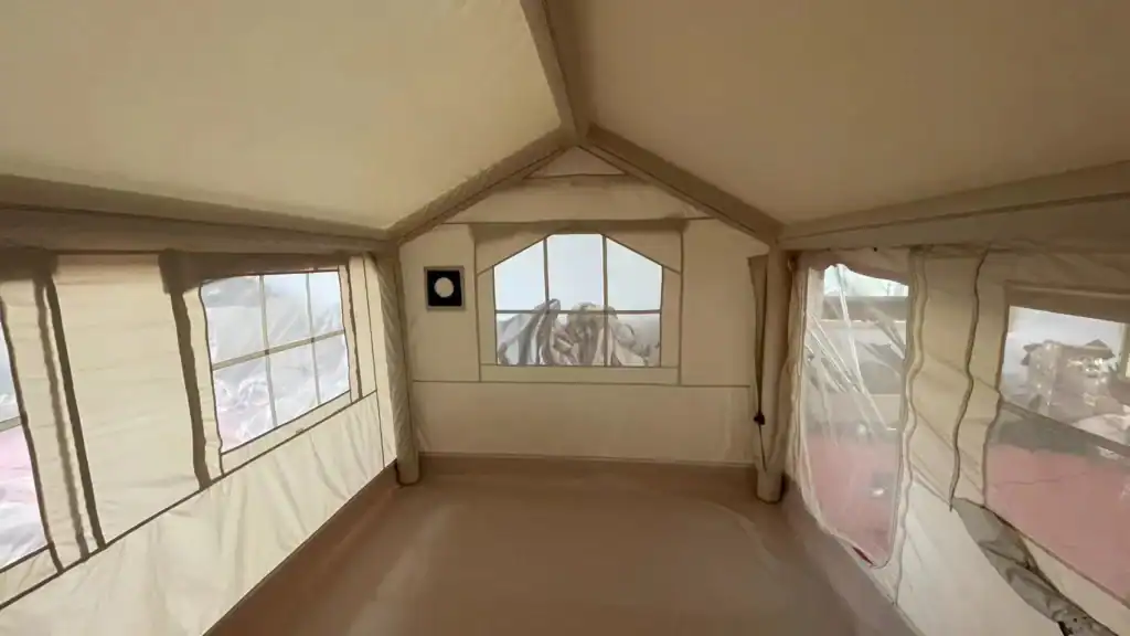 Outdoor tent interior with large windows and scenic views.