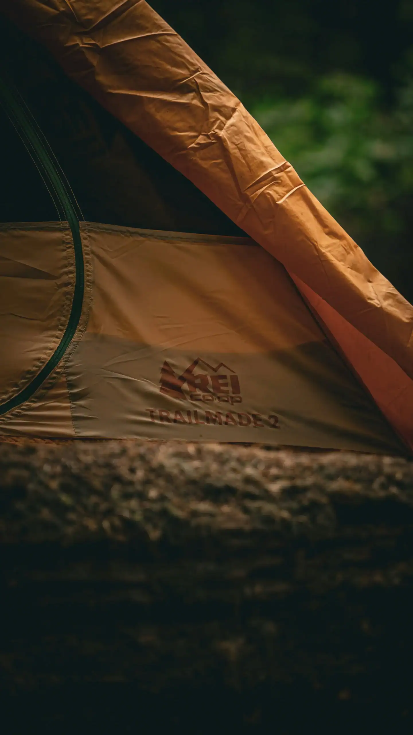 Outdoor camping tent set up in a lush green forest environment.