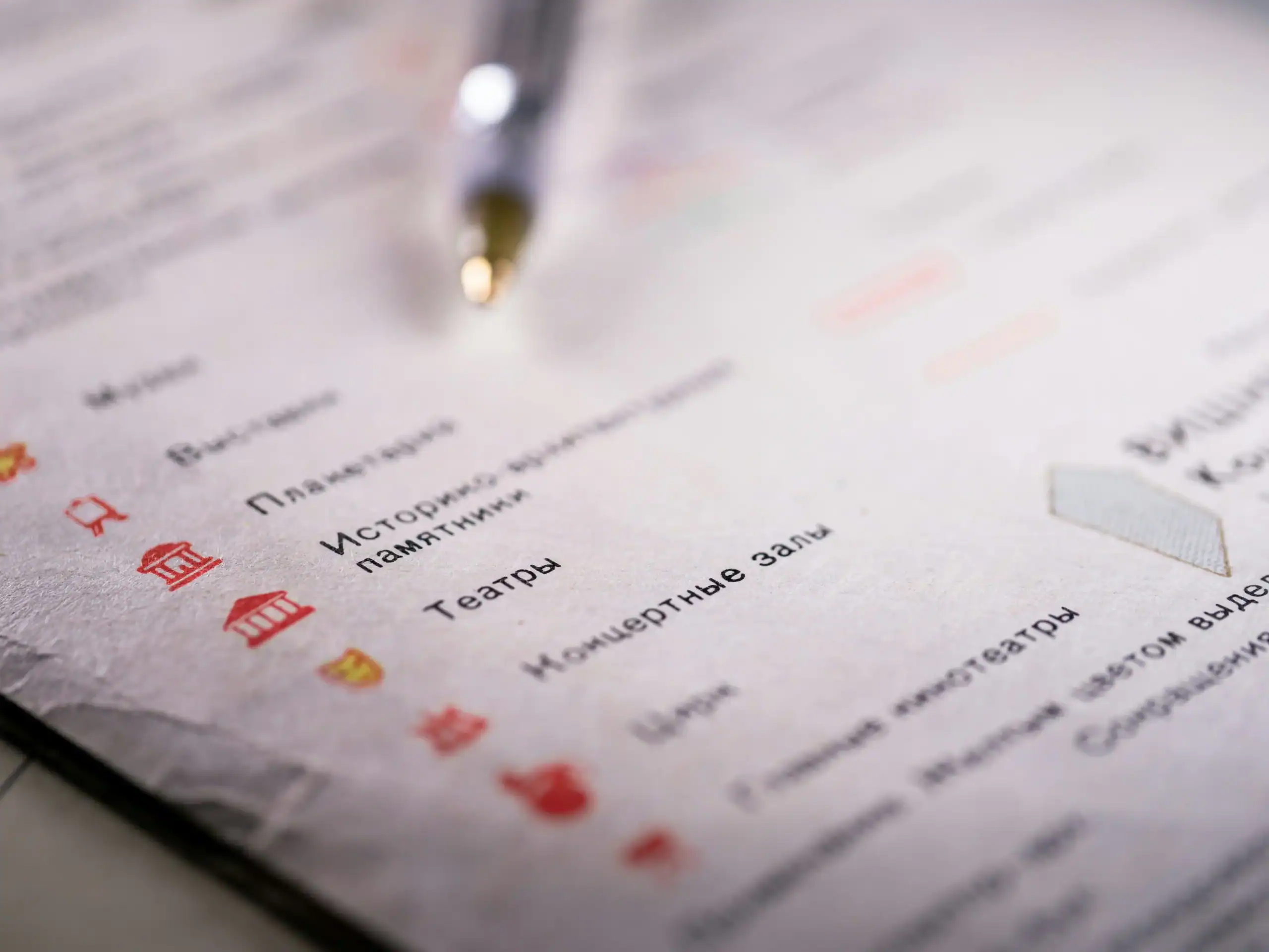 Outdoor activity planning with a pen and paper on a blurred background.