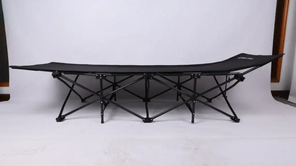 Camping Cot Safety Standards: Avoid $50k Compliance Failures 4 Black foldable camping cot with a durable frame and fabric, set against a plain indoor studio background.