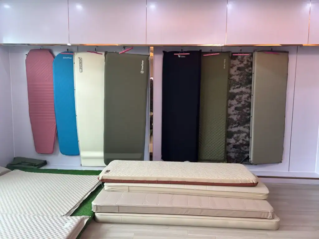 Air Mattress Leaks: 5 Hidden Weld Failures & Fixes 5 Various foam mattresses and camping pads displayed in a store for outdoor sleeping gear.