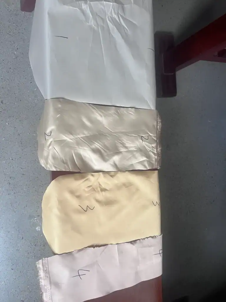 Polyester vs Nylon Tent Cost: Hidden Margins Revealed 2 Four fabric samples in varying shades and textures, marked with numbers and letters, displayed on a flat surface.