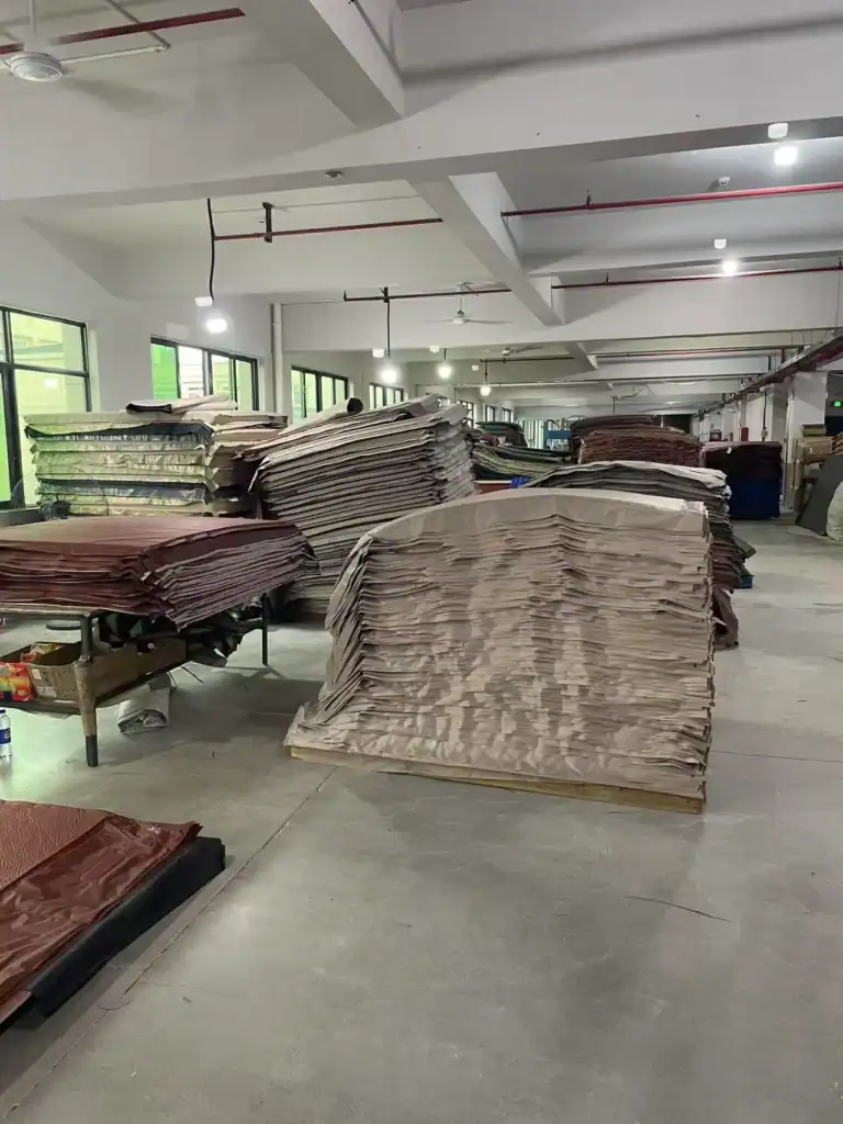 Air Tent vs Pole Tent: 5 Failure Modes B2B Buyers Must Know 3 Stacks of fabric or upholstery material in a spacious industrial warehouse.