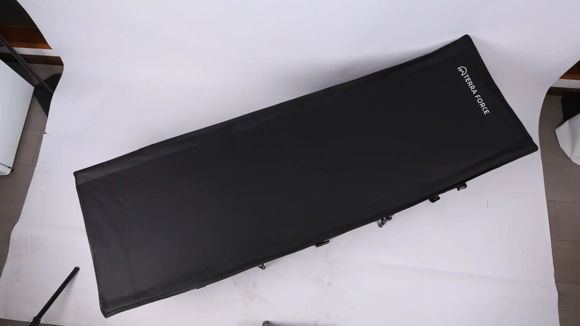Folding Wagon Packaging Drop Test: The 60cm Export QC Rule 127 Black folding camping cot with durable fabric and sturdy legs displayed on a white backdrop.