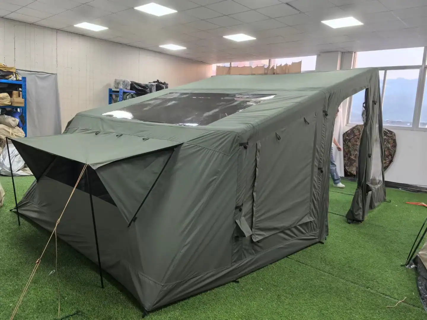 Inflatable Tent Setup Time vs Pole Tents: Retail Data 124 Large green camping tent with transparent window in indoor setting.