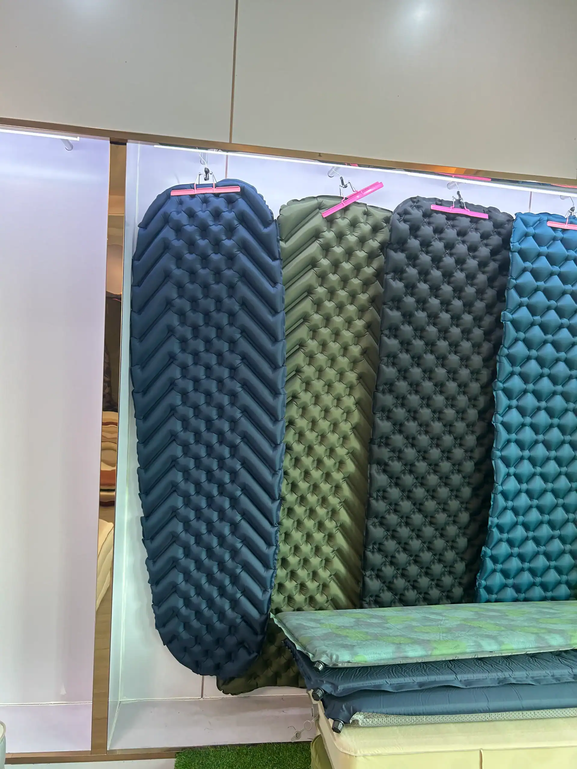 Colorful sleeping pads hanging on display at Kelyland Outdoors.