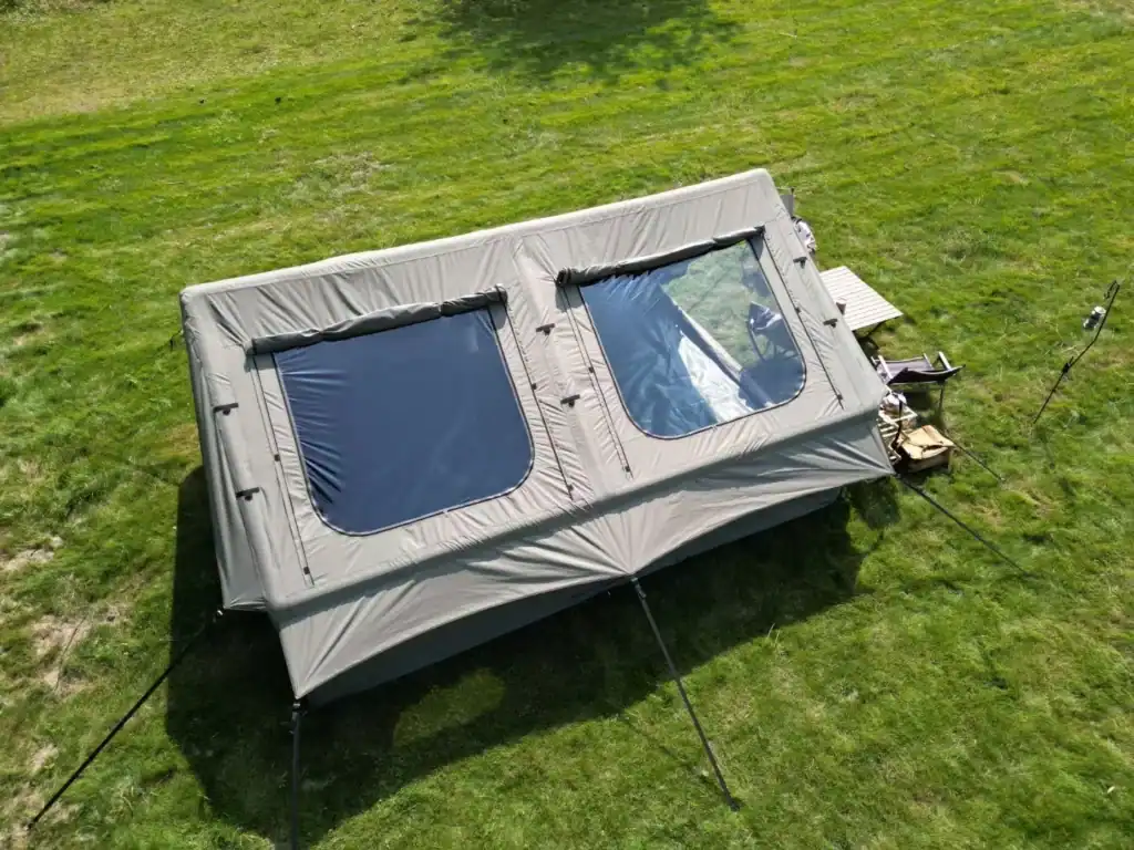Smart Tent Sourcing: How Kelyland Closed the Quality Gap 2 Gray camping tent with two windows on green grass field.