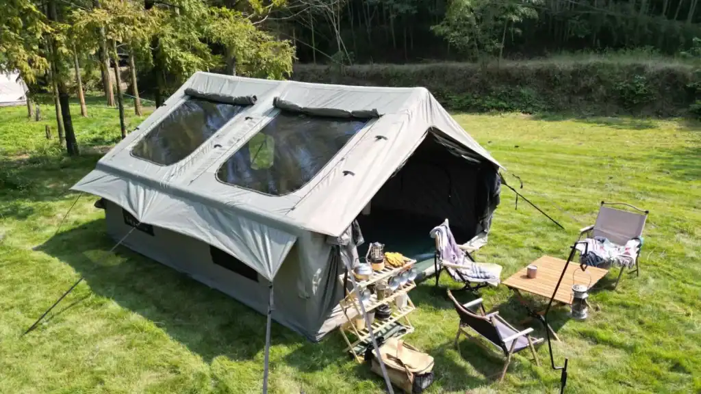 Smart Tent Sourcing: How Kelyland Closed the Quality Gap 3 緑豊かな芝生の上に座席エリアを備えた大型アウトドアキャンピングテント。.