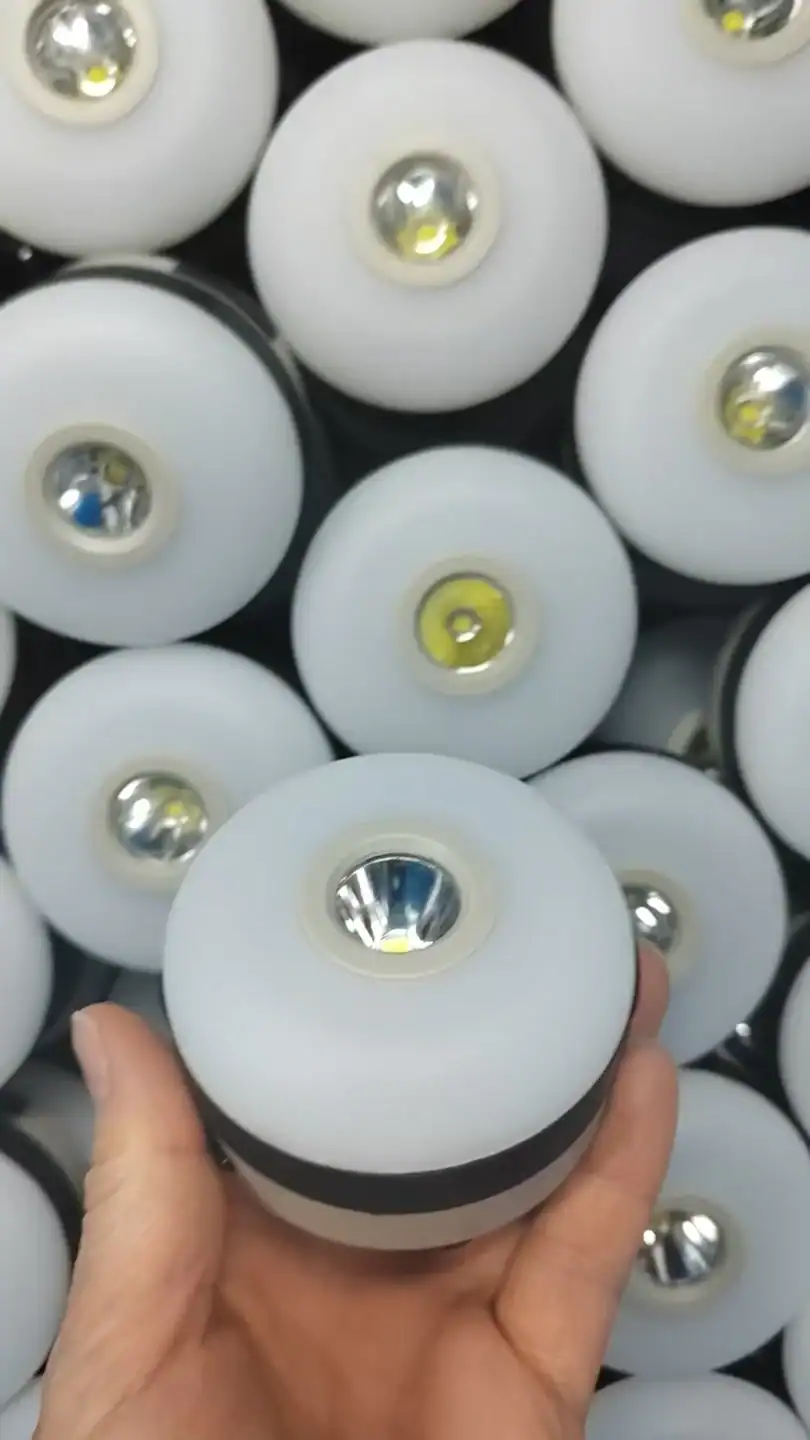 Close-up of white LED bulbs with reflective centers, held in hand.