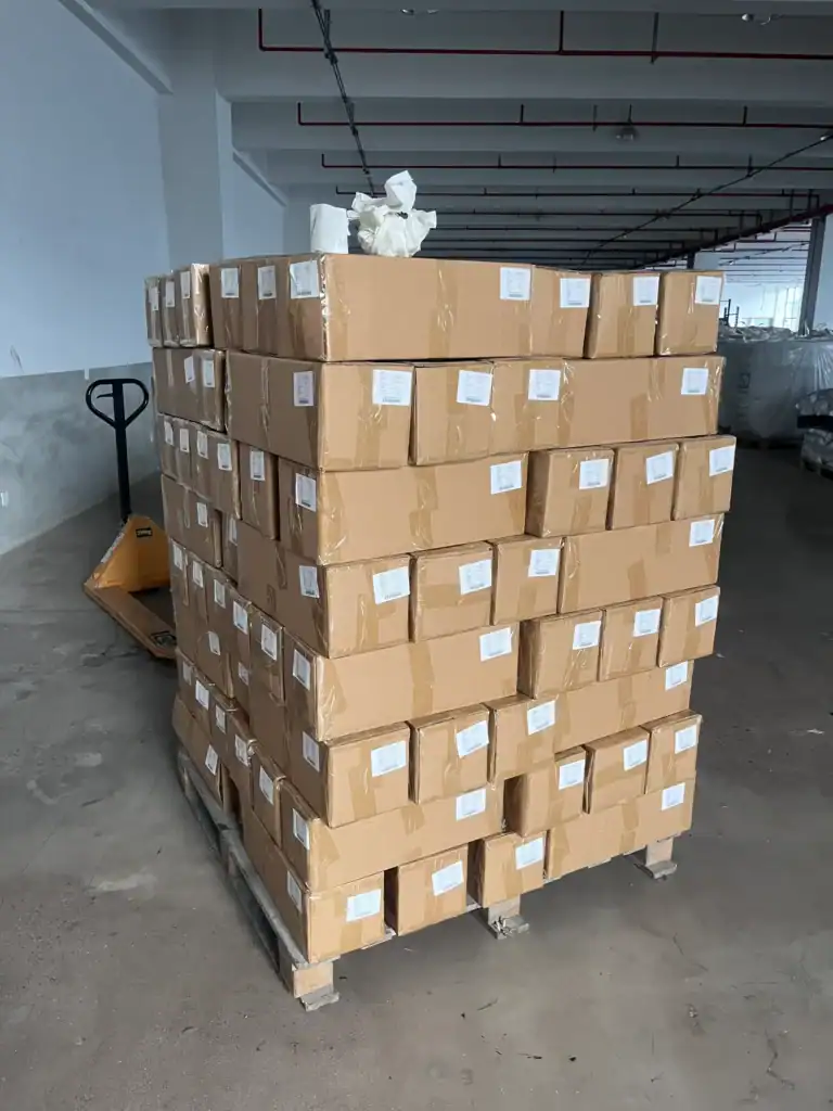 Custom Inflatable Tents TPU Blends Quality Control Guide 5 A pallet loaded with neatly stacked sealed carton boxes in a spacious warehouse, ready for shipping or storage.