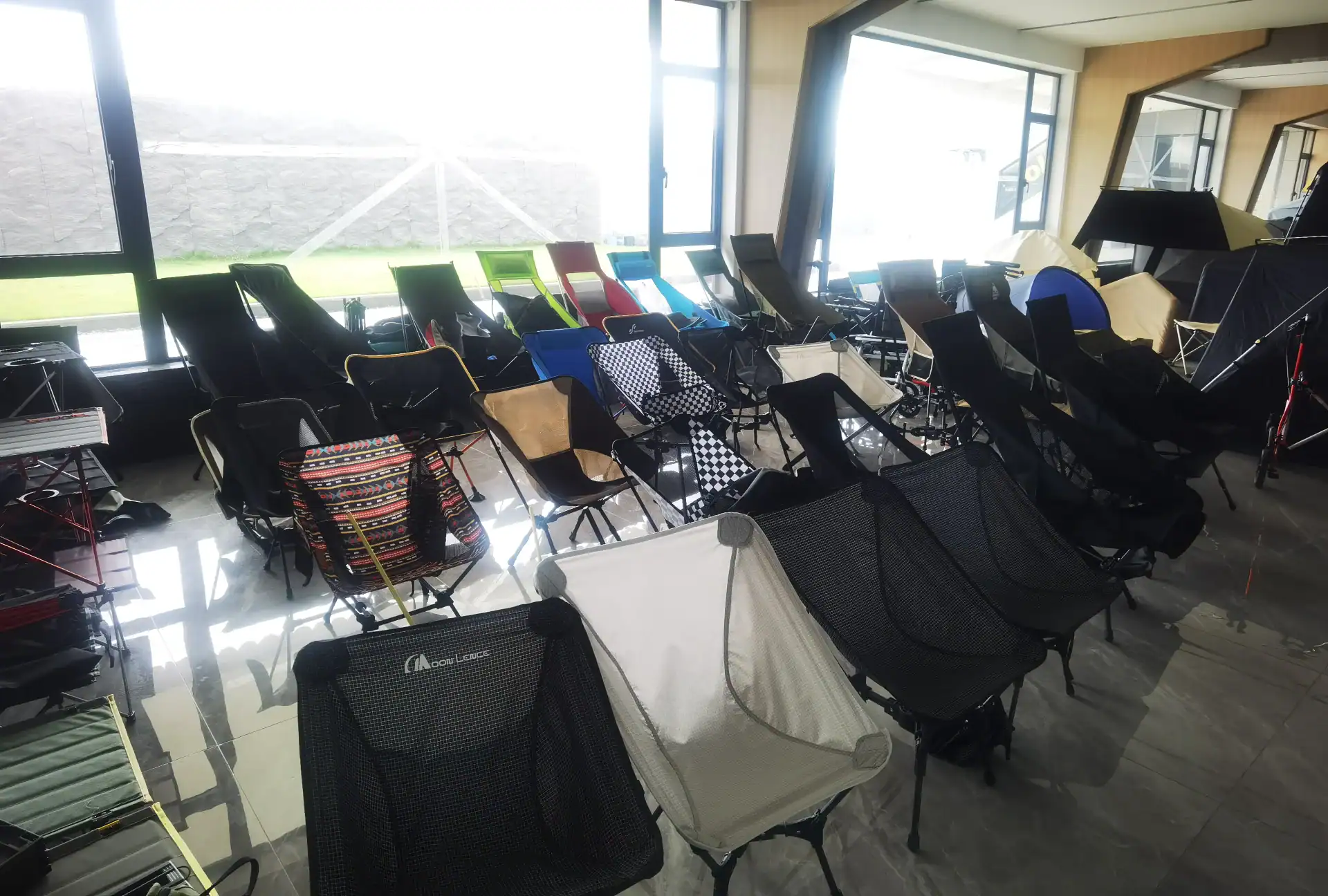Inflatable Tent Valve Repair: Stop Cracks From Deflation 19 A variety of camping chairs with different designs and colors displayed indoors in a well-lit showroom with large windows.