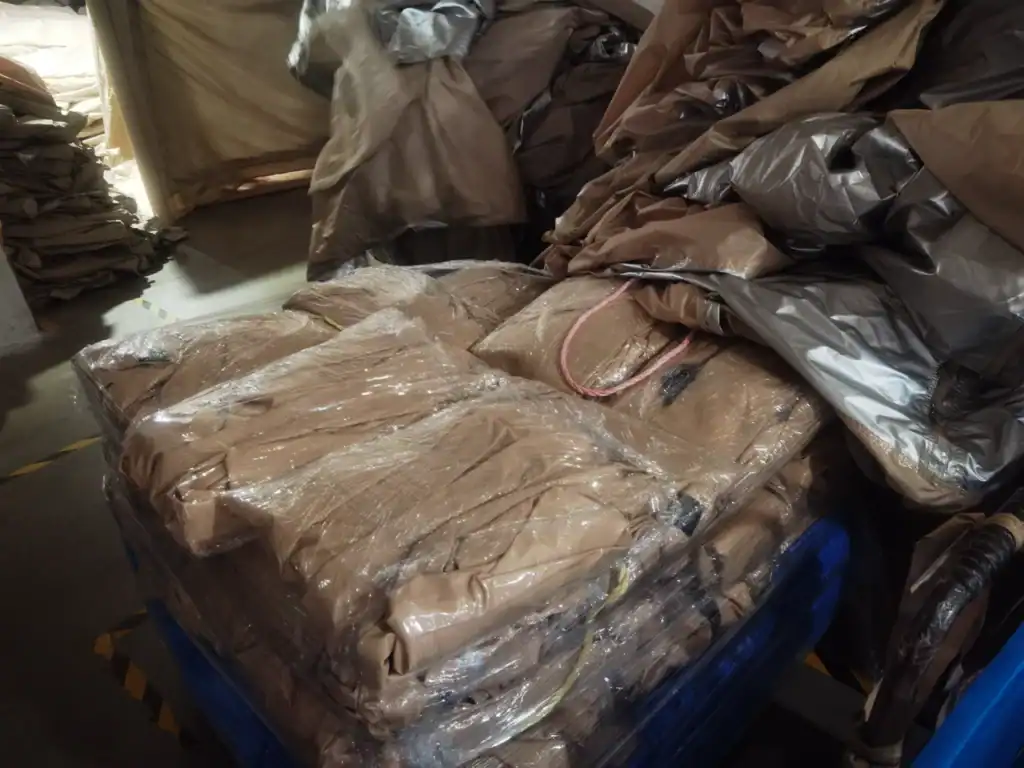 Custom Inflatable Tent Case Study: 45-Day Retail Launch 4 Plastic-wrapped camping gear and brown fabrics stored in a warehouse setting, organized on pallets.