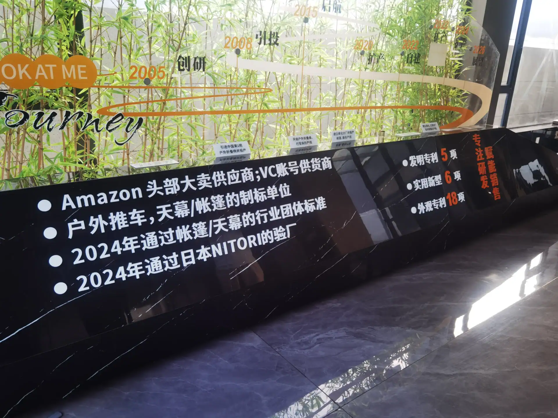 Inflatable Tent Cleaning: 7 Steps to Save PU Coatings 20 A display showing a company's timeline and achievements with greenery in the background and information in Chinese and English text.