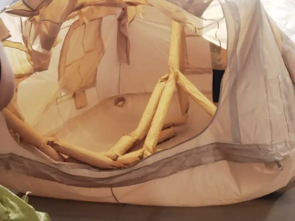 Tienda de camping parcialmente inflada con tubos de aire visibles en su interior, que muestra su estructura durante el montaje.