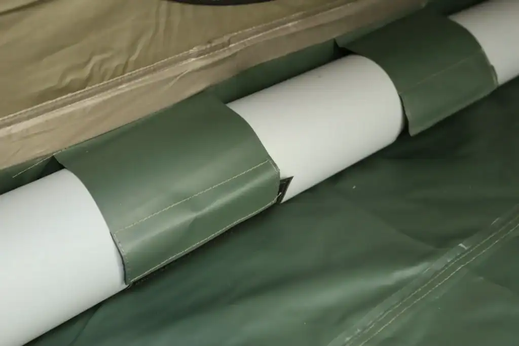 Green and white outdoor tent fabric with rolled-up sections for camping gear.
